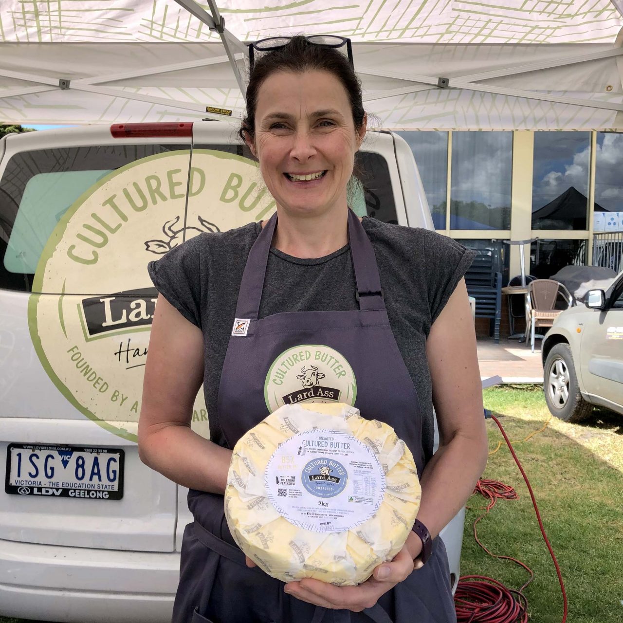 A stallholder holding a wheel of cultured butter at Slow Food Melbourne Spotswood